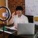 Employee reviewing Bitcoin graphics on a laptop, highlighting cryptocurrency-based compensation.