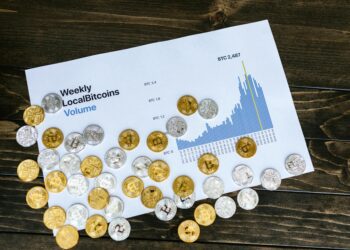 Bitcoin coins stacked with a graph showing increasing inflows amid financial charts and news headlines.