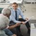 A financial advisor discusses cryptocurrency investment options with clients at a Schwab office.
