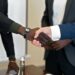 Coreweave and Anthropic executives shaking hands in an office setting, symbolizing partnership.