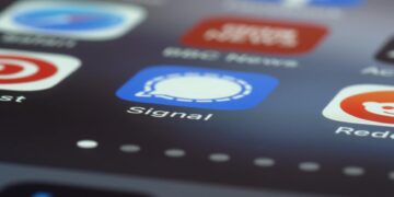 Apple logo displayed on a smartphone screen with a Signal app notification.