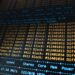 A computer screen displays blockchain code while Bitcoin symbols surround it.