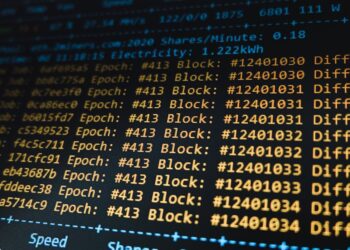 A computer setup displaying Bitcoin mining software and a reward announcement.