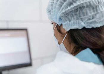 Laboratory technician analyzing data on a computer screen, showcasing AI drug discovery.