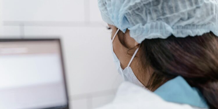 Laboratory technician analyzing data on a computer screen, showcasing AI drug discovery.