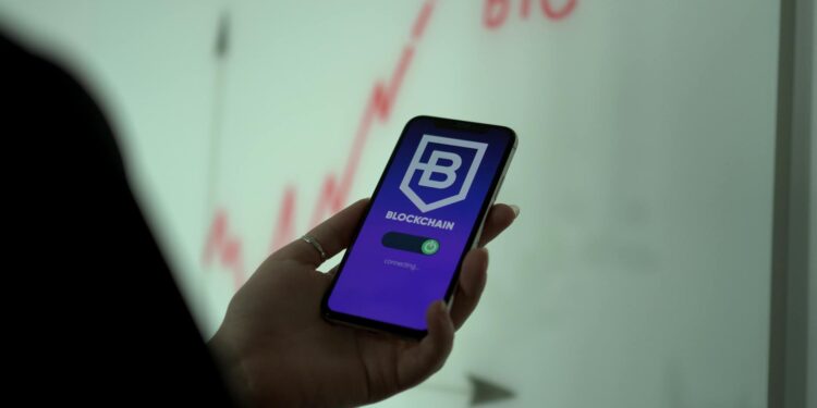 Revolut logo on a smartphone screen with financial graphs and crypto symbols in the background.