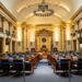 Senators discussing cryptocurrency regulation in a legislative chamber before the vote.