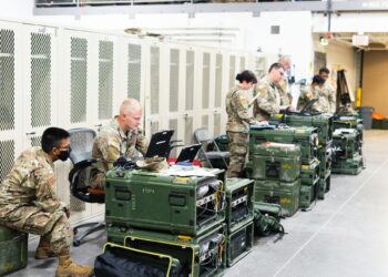 Military personnel examining a Bitcoin node setup in a secure facility.