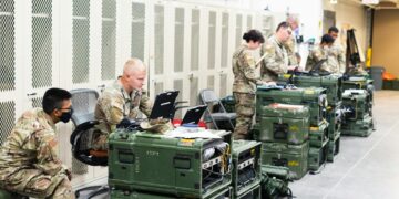 Military personnel examining a Bitcoin node setup in a secure facility.