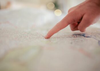 Trump gestures during a speech, outlining US withdrawal plans from Iran with a map beside him.