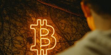 TRON DAO and Securitize logos with a Bitcoin backdrop at a finance event.