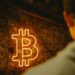 TRON DAO and Securitize logos with a Bitcoin backdrop at a finance event.