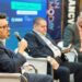 Two men on stage discussing cryptocurrency at a conference in Miami.