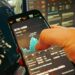 A man checks cryptocurrency prices on a smartphone amidst financial news articles.