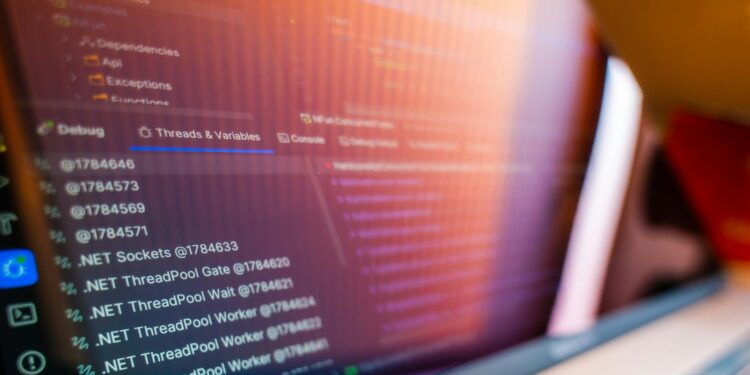 A computer screen displaying coding symbols with a warning sign about Linux vulnerabilities.