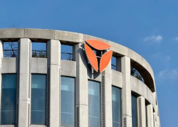 A Bithumb office building with cryptocurrency logos, reflecting recent legal changes.