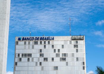 Brazilian bank building with digital currency symbols and a ban sign overlay.