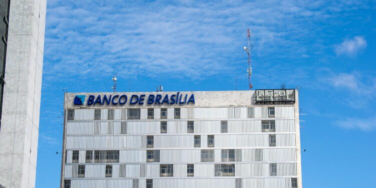 Brazilian bank building with digital currency symbols and a ban sign overlay.