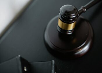 A gavel rests on financial documents, symbolizing legal settlement in crypto fraud case.