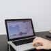 A person looking at a laptop displaying cryptocurrency graphs and AI algorithms.
