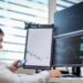 Traders analyzing stock charts with digital screens showcasing tokenized stocks and ETFs.