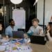 A group of diverse professionals discusses regulations on prediction markets in a conference room.