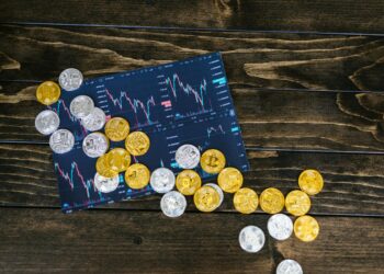 Crypto coins scattered with a backdrop of financial charts and sanctions symbols.