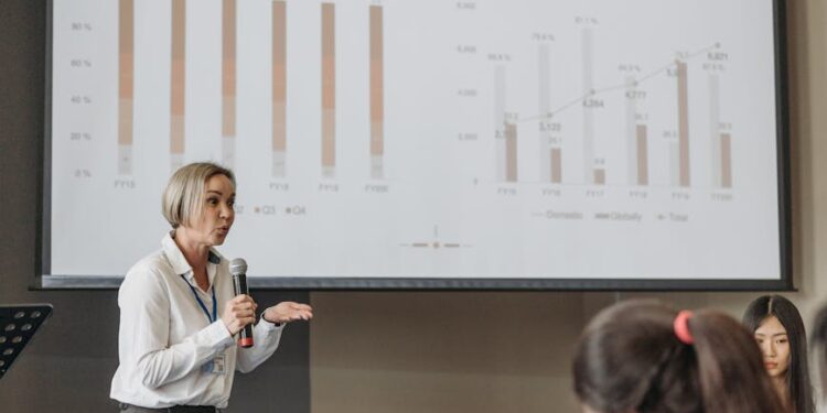 Peter Thiel speaking at a finance conference, with charts and graphs in the background.